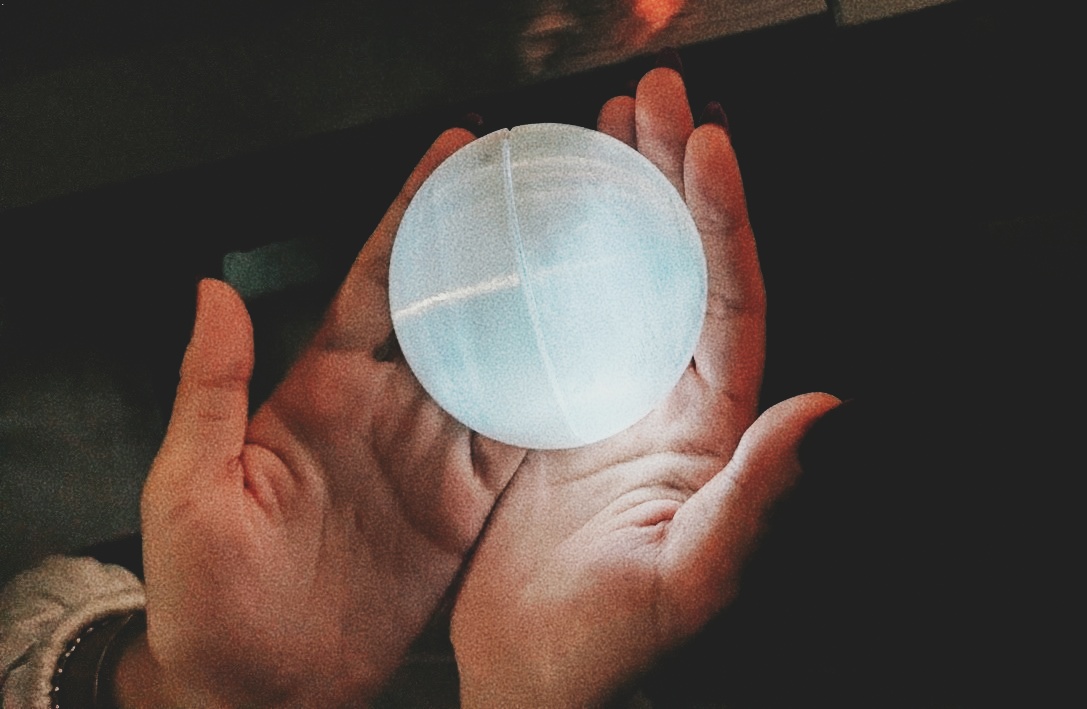 Two cupped hands holding the glowing Breathing Pod